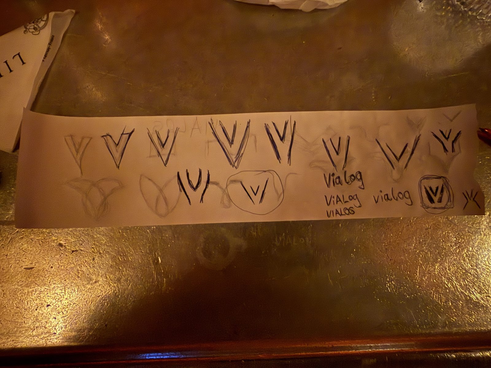 Ein Papierstreifen mit rund einem Dutzend Handskizzen der Bildmarke in Varianten